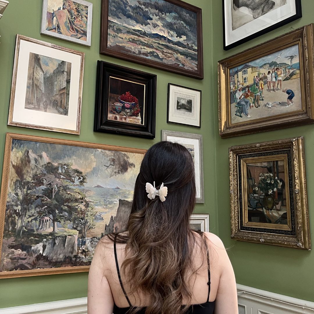 pearl white butterfly clip worn in dark hair art gallery setting