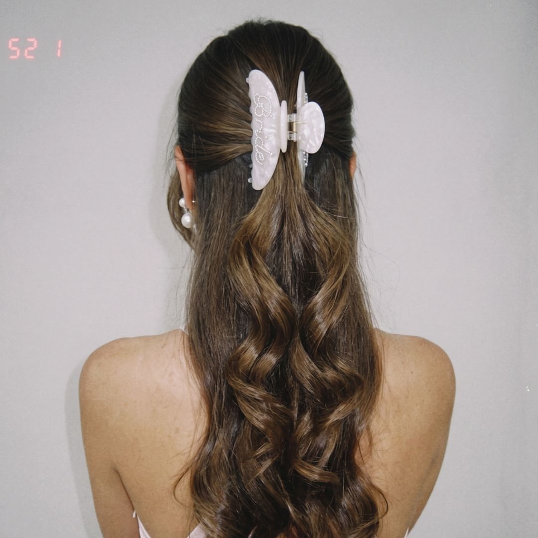 Bride wearing pearl bridal claw clip in half-up wavy hairstyle