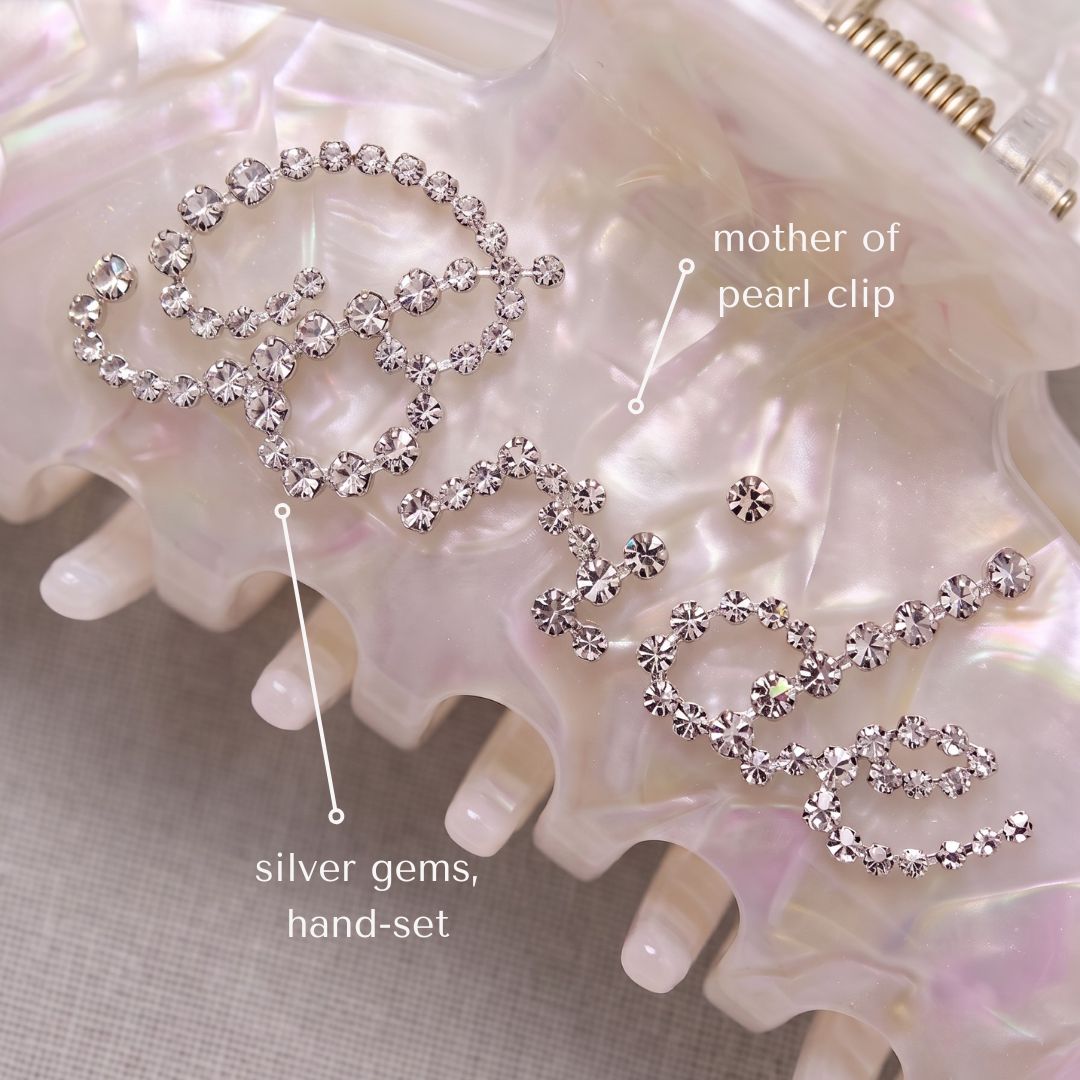 Close-up of hand-set crystal 'Bride' script on pearl hair clip